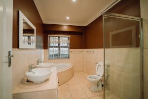 een badkamer met 2 wastafels, een toilet en een douche bij Rondebosch Luxury Living in Kaapstad