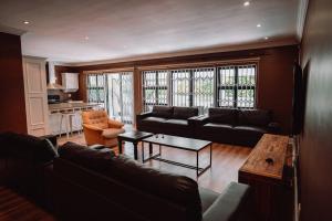een woonkamer met een bank en een tafel bij Rondebosch Luxury Living in Kaapstad