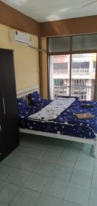 Un dormitorio con una cama con sábanas azules y una ventana. en La Canteena, en Pattaya South 4 fotos más