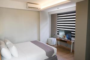 A bed or beds in a room at Allstay Hotel Semarang Simpang Lima