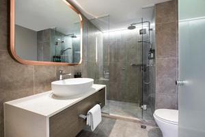 a bathroom with a sink and a shower with a mirror at Crowne Plaza Melbourne, an IHG Hotel in Melbourne