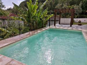 einen Pool in einem Hof mit einer Pergola in der Unterkunft Refúgio do Abade in Terras de Bouro