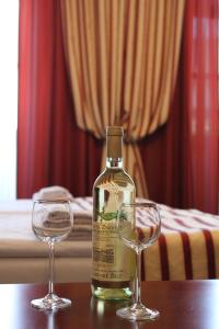 a bottle of wine and two glasses on a table at Penzion U Císaře Zikmunda in Znojmo