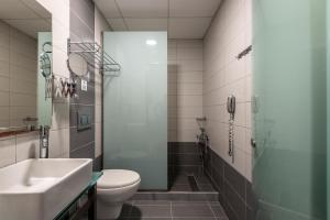 a bathroom with a toilet and a sink and a shower at Royal Bay Suites in Kefalos