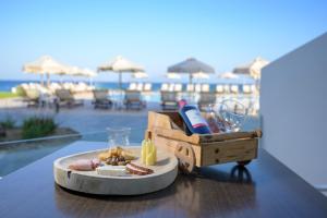 a table with a plate of food and wine on a table at Royal Bay Suites in Kefalos
