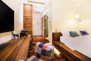 1 dormitorio con 1 cama y escritorio con ordenador en The Daulat by Hotel Calmo en Singapur