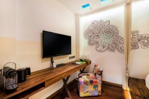 a desk with a bookcase and a television on top of it at The Daulat by Hotel Calmo in Singapore