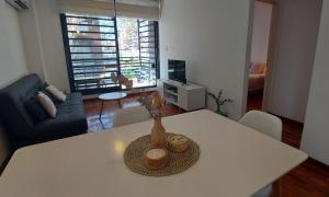 a table with a vase on it in a living room at Cálido y hermoso Dpto. en excelente zona de Rosario in Rosario