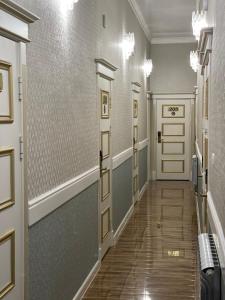a hallway with doors and wood floors and a hallwayngth at Гостиница АСКАР in Shymkent