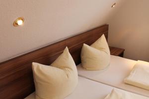 2 almohadas sentadas en una cama en una habitación en Hotel Uhl, en Rothenburg ob der Tauber
