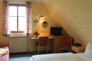 a bedroom with a desk with a computer and two chairs at Hotel Uhl in Rothenburg ob der Tauber