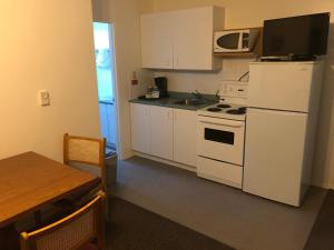 a kitchen with a white refrigerator and a microwave at Mountain Springs Motel in Radium Hot Springs