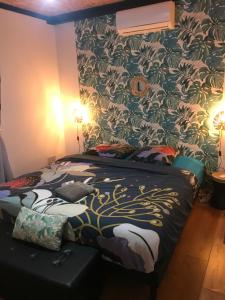 Schlafzimmer mit einem Bett mit Blumentapete in der Unterkunft La Villa Citronnier in Petite Île