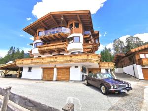 a car parked in front of a large building at Schickster Sky Lodge in Leutasch