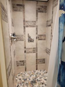 ein Bad mit einer Dusche und Fliesenboden in der Unterkunft The Colburn Schoolhouse - Geography suite in Sandpoint