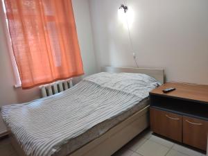 a small bedroom with a bed and a window at Globe Hostel in Barnaul