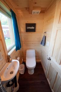 a small bathroom with a toilet and a sink at Tuxbury Pond Camping Resort Tiny House Emerson in South Hampton