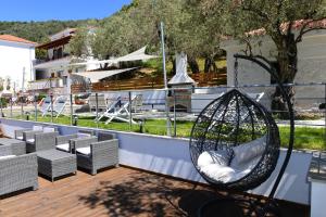 a swing on a balcony with chairs and a fountain at SKIATHOS-FILOKALIA in Achladies