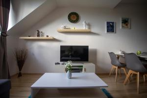 a living room with a white table and a tv at Apartmán Angel in Veľká Lomnica