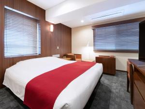 a bedroom with a large bed and a television at Central Hotel Okayama in Okayama