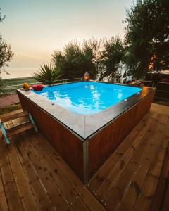 a swimming pool on a wooden deck with a wooden floor at Natura Club Hotel & Spa - Adults Only in Kyparissia