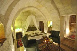 um quarto com uma cama num quarto de pedra em Hotel Elvan Cave House em Ürgüp