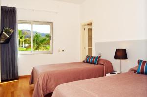 a hotel room with two beds and a window at Villas Opal Anfi Tauro in Puerto Rico de Gran Canaria