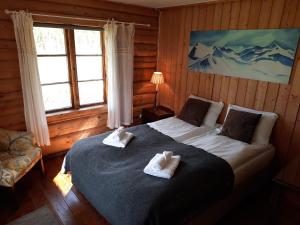 a bedroom with a bed with two towels on it at Phillipshaugen Lodge in Øksendalsøra +30 photos