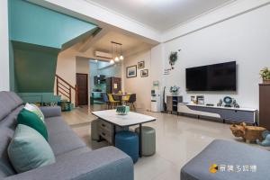 uma sala de estar com um sofá e uma televisão em Sunny No85 B&B em Toucheng