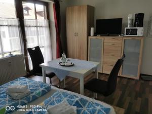 a living room with a table and a tv at Aparthotel Chrysantihof - Fewo - Alois in Zwiesel