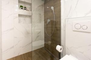 a bathroom with a shower with a glass door at Castel Beachfront Apartment in Kaštela +29 photos