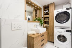 a laundry room with a sink and a washing machine at Castel Beachfront Apartment in Kaštela