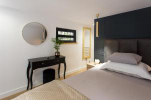 una camera con letto, specchio e tavolo di Castel Beachfront Apartment a Kaštela (Castelli)