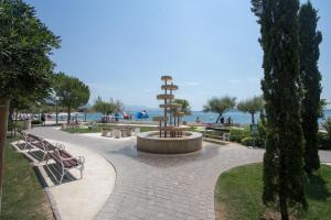 a park with benches and a fountain and the water at Castel Beachfront Apartment in Kaštela