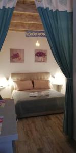 a bedroom with a bed with blue curtains at Alghero Old Town Apartment in Alghero +11 photos