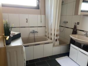 a bathroom with a bath tub and a sink at Ferienwohnung Sonnenschein in Bad Hersfeld