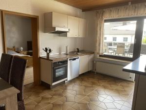 uma pequena cozinha com um fogão e uma janela em Ferienwohnung Sonnenschein em Bad Hersfeld