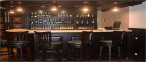 a bar with wooden chairs and bottles of wine at Hotel Atithi in Guwahati