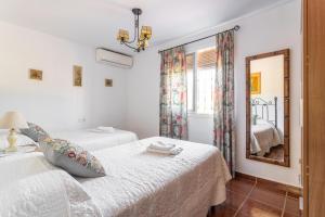 een slaapkamer met twee bedden en een spiegel bij Casita Puente Viejo in Nerja +17 foto's