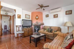 uma sala de estar com um sofá e uma televisão em Casita Puente Viejo em Nerja