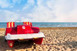 里米尼的住宿－Hotel Nuovo Giardino，一辆红色卡车坐在海滩上