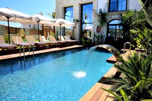 a swimming pool with a fountain in a building at Dmira Alacati in Alaçatı