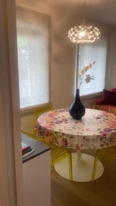 a dining room table with a vase on top of it at Casa sciliar blu centro paese in Völs am Schlern