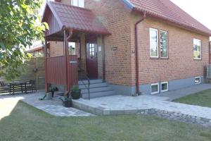 a brick building with a red door and stairs at Kärraton Stugor Centrala Åhus in Åhus