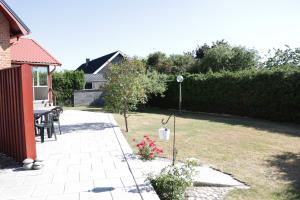 a garden with a table and chairs and flowers at Kärraton Stugor Centrala Åhus in Åhus