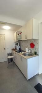 a kitchen with white cabinets and a sink at LUNA in Oradea +10 photos