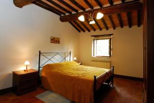 ein Schlafzimmer mit einem gelben Bett in einem Zimmer mit einem Fenster in der Unterkunft A stay surrounded by greenery - Agriturismo La Piaggia -app 3 guests in Vivo dʼOrcia
