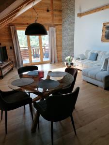 ein Wohnzimmer mit einem Tisch und Stühlen in der Unterkunft Chalet les Ecureuils Apartment Penthouse Suite in Crésuz