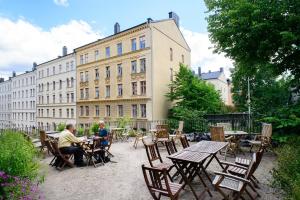 duas pessoas sentadas à mesa em frente a um edifício em Hotel Hellstens Malmgård em Estocolmo