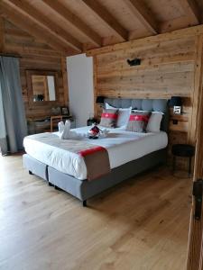 Schlafzimmer mit einem großen Bett und Holzwänden in der Unterkunft Chalet les Ecureuils Apartment Penthouse Suite in Crésuz